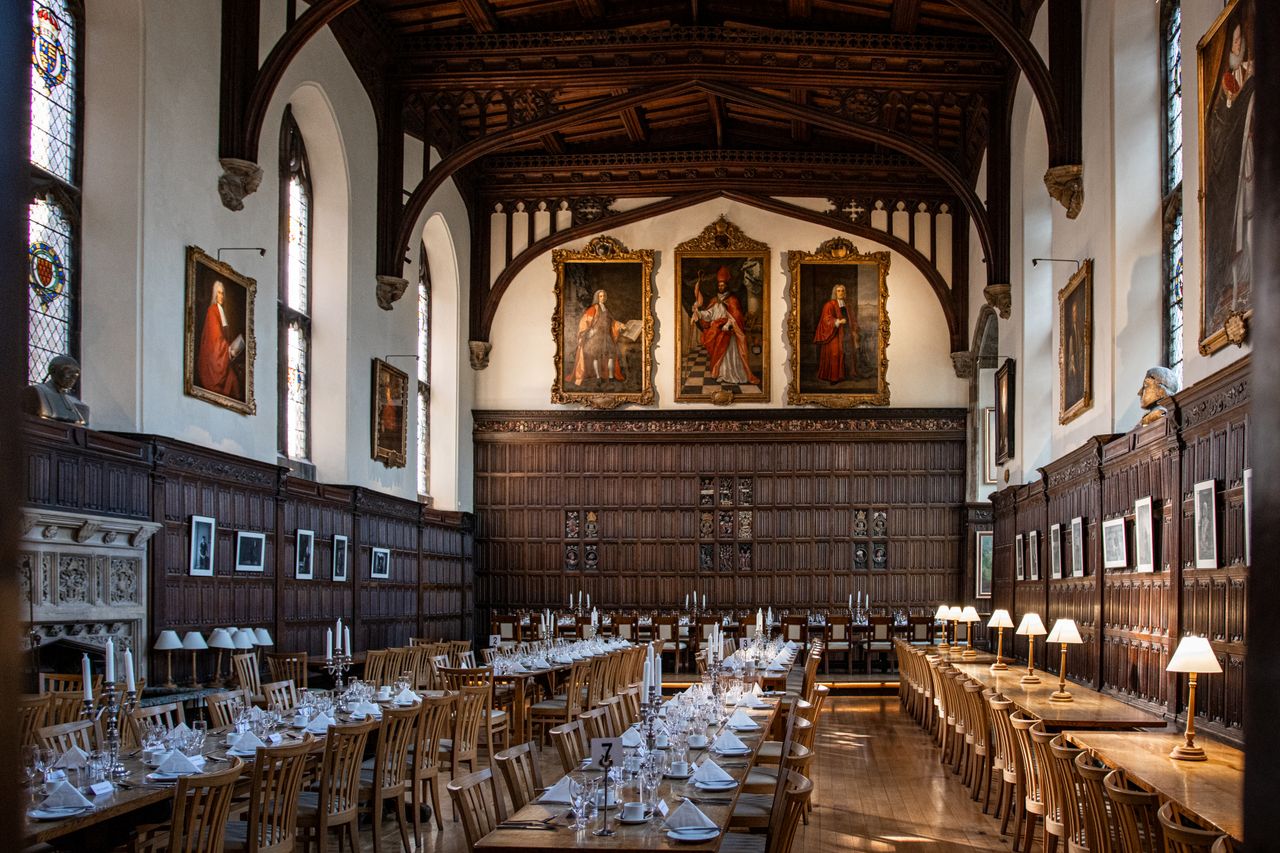 Services Historic dining hall with elaborately set tables in Magdalen College, Oxford.